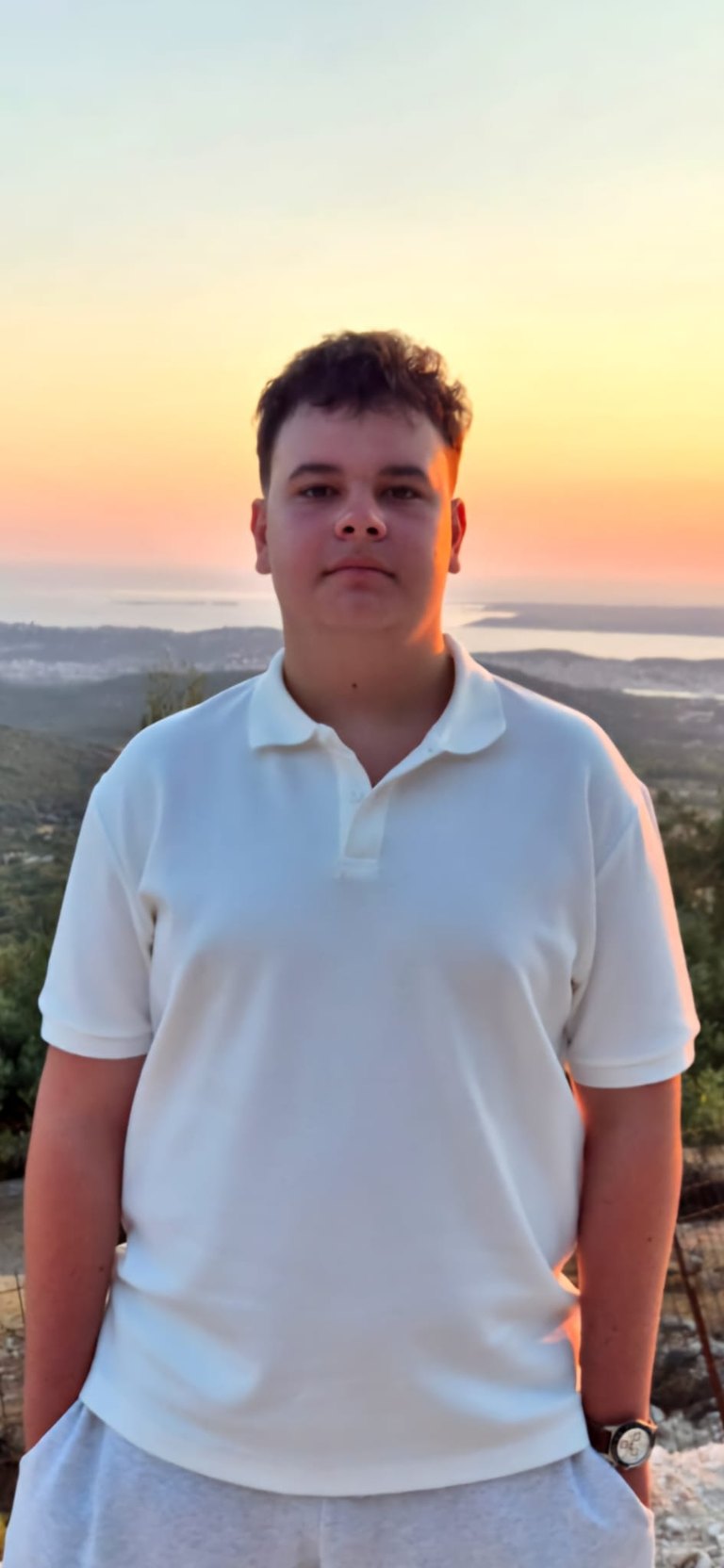Nicholas Carstoiu, Romanian youth leader and student-athlete, at sunset over a coastal landscape